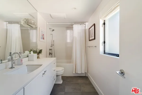 a bathroom with a double vanity sink toilet mirror and shower