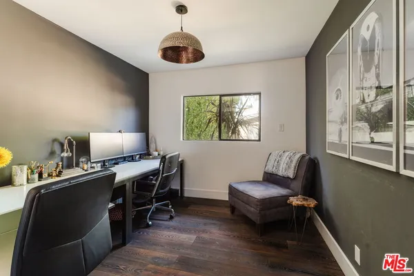 a view of a workspace with furniture and a window