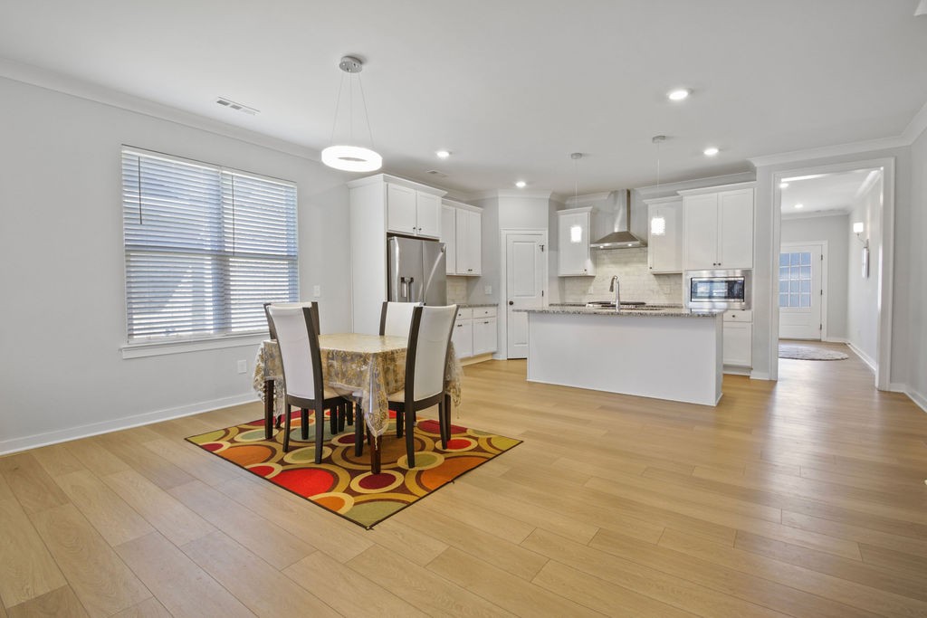 917 Plowson Road Mount Juliet, TN 37122 - Photo 13 of 47 a view of a dining room with furniture a kitchen and chandelier