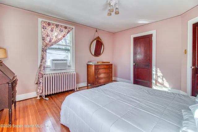 an empty room with windows wooden floor and front door