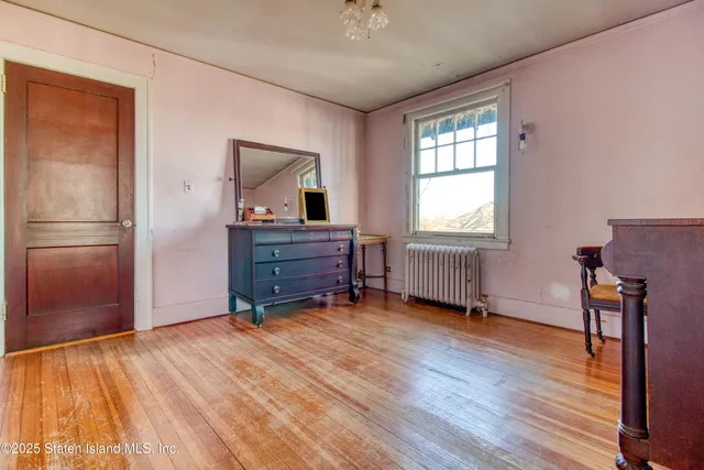 a view of a hallway with wooden floor and windows