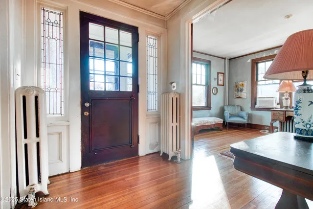 a view of a living room with a large window and wooden floor