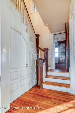 a living room with furniture a rug wooden floor and a large window