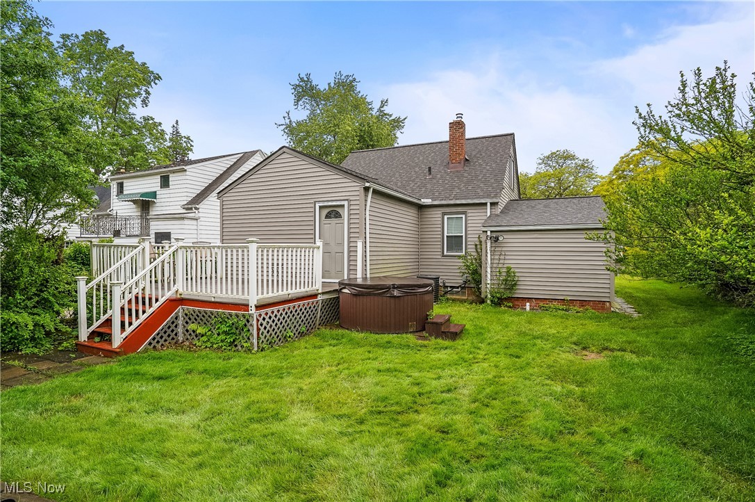 1527 Sunview Road Cleveland, OH 44124 - Photo 18 of 27 Back of house with a hot tub, a deck, a yard, a chimney, and roof with shingles