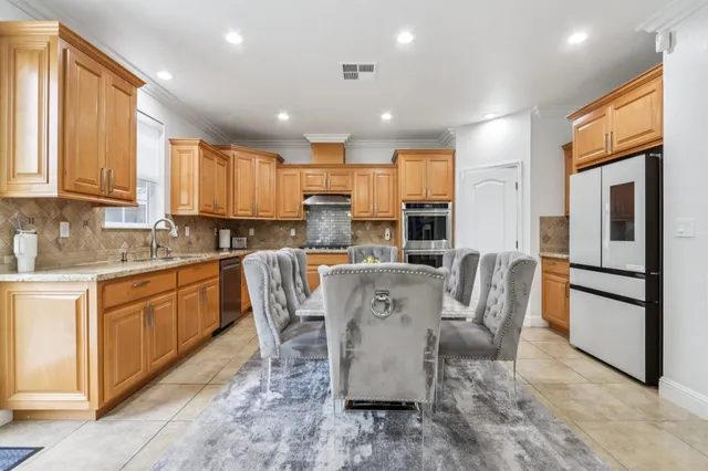 a living room with furniture kitchen view and a large window