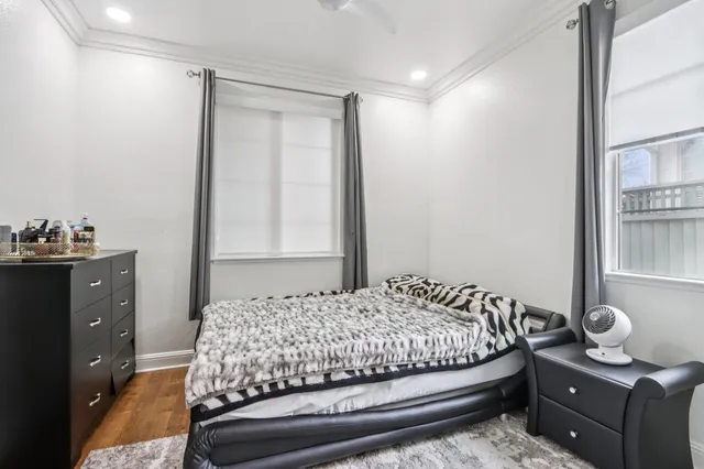a living room with a bed furniture flat screen tv and window