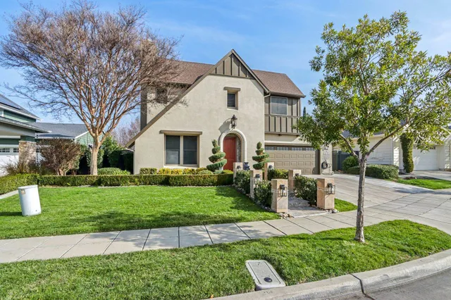 a view of a white house with a table and chairs