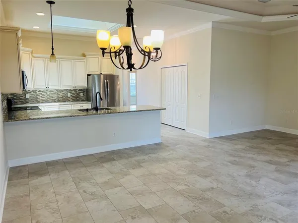 a kitchen with kitchen island stainless steel appliances a chandelier