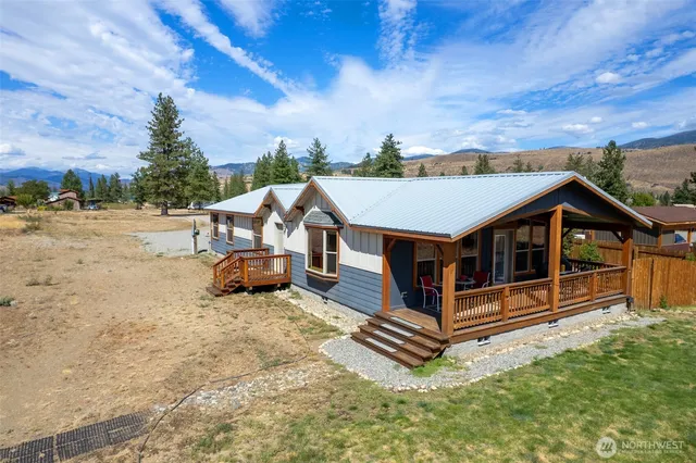 a view of a house with a wooden deck and furniture