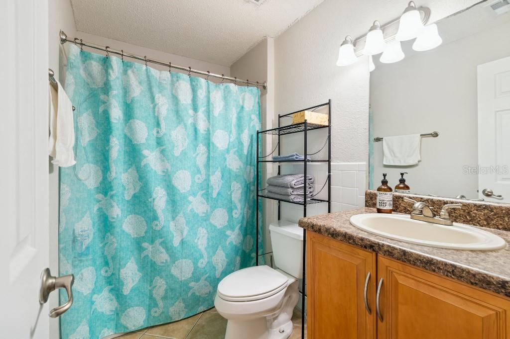 13125 Wilcox Road, Unit 6205 Largo, FL 33774 - Photo 22 of 48 a bathroom with a granite countertop sink a toilet and a mirror