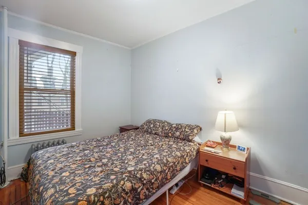 a bedroom with a bed and a lamp on desk