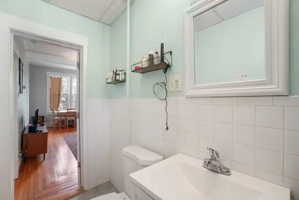 a bathroom with a sink a toilet and mirror