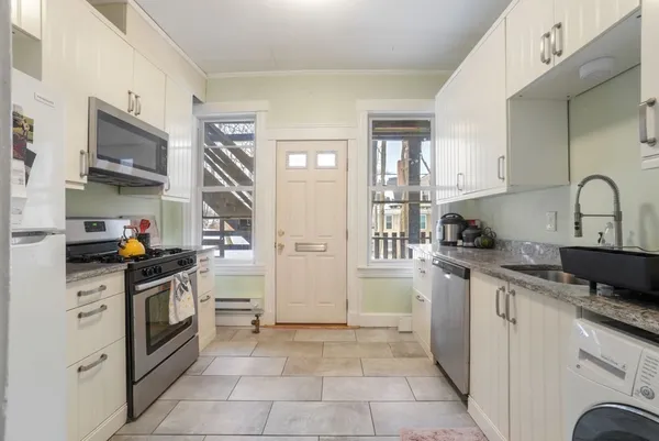 a kitchen with stainless steel appliances granite countertop a refrigerator and a stove top oven
