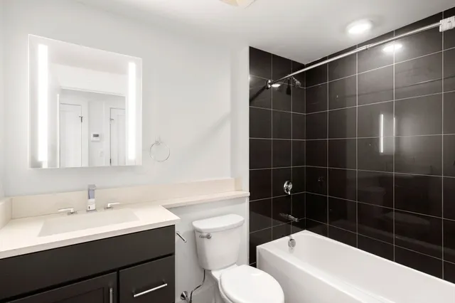 a bathroom with a sink toilet vanity and shower
