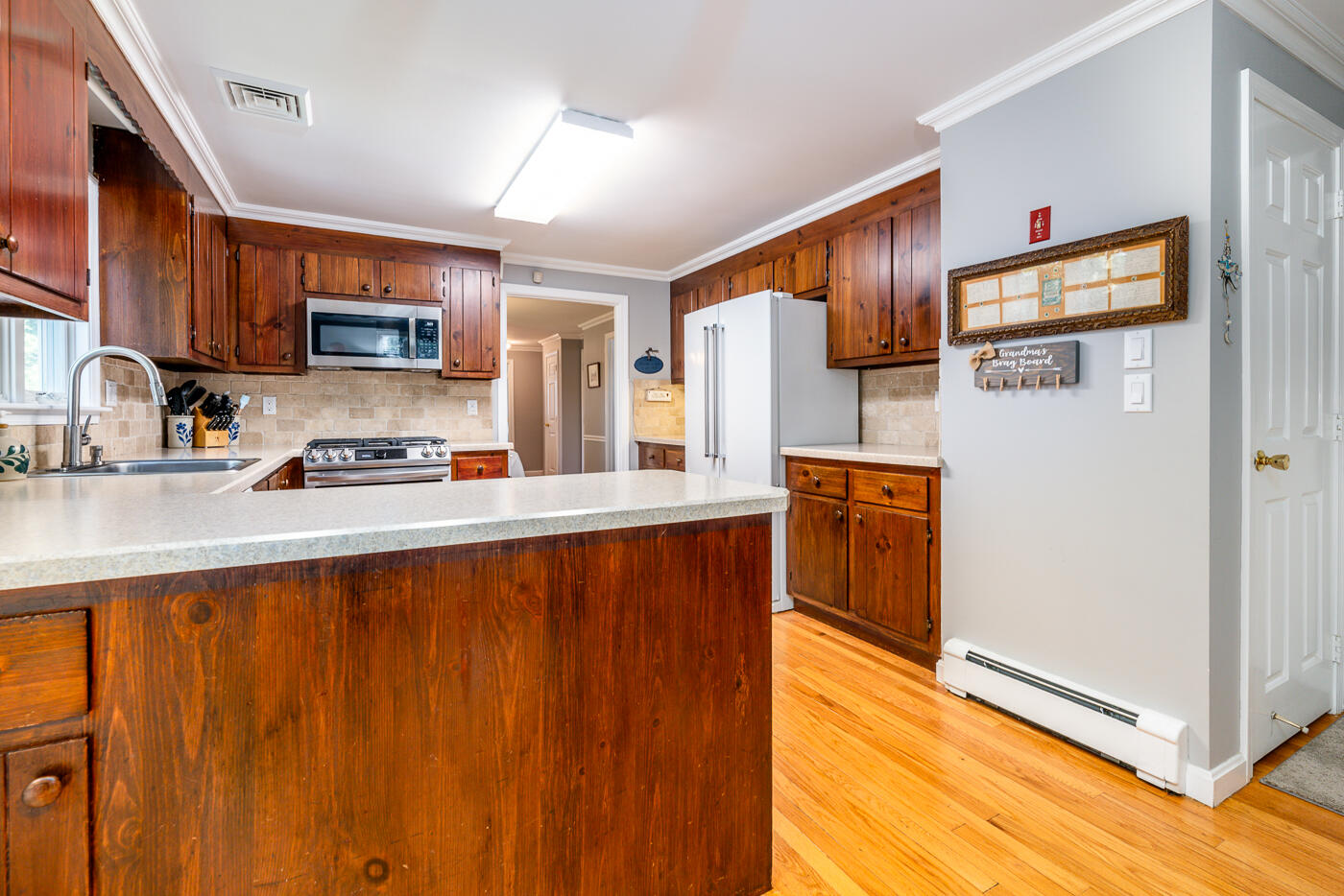 41 Joyce Anne Road Centerville, MA 02632 - Photo 8 of 33 a kitchen with stainless steel appliances granite countertop a refrigerator a sink dishwasher and wooden cabinets with wooden floor