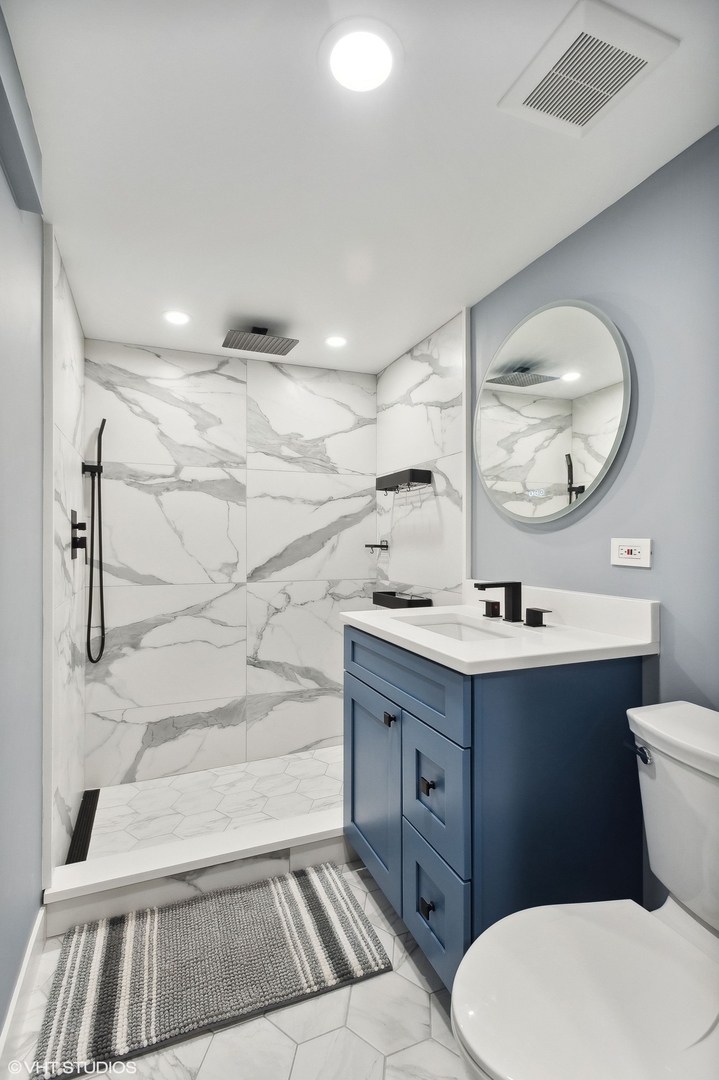 2949 North Rutherford Avenue Chicago, IL 60634 - Photo 13 of 23 a bathroom with a sink a toilet and a mirror