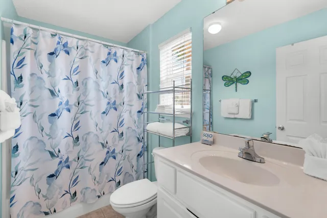 a bathroom with a sink vanity mirror and toilet