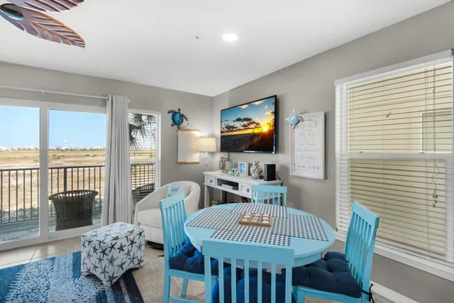 a kitchen with stainless steel appliances kitchen island granite countertop a stove a sink dishwasher a dining table and chairs with wooden floor