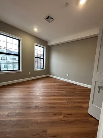 a view of a room with wooden floor and a window