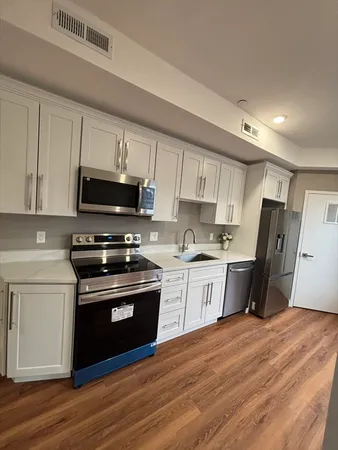 a kitchen with stainless steel appliances a stove top oven a sink dishwasher a refrigerator and a microwave