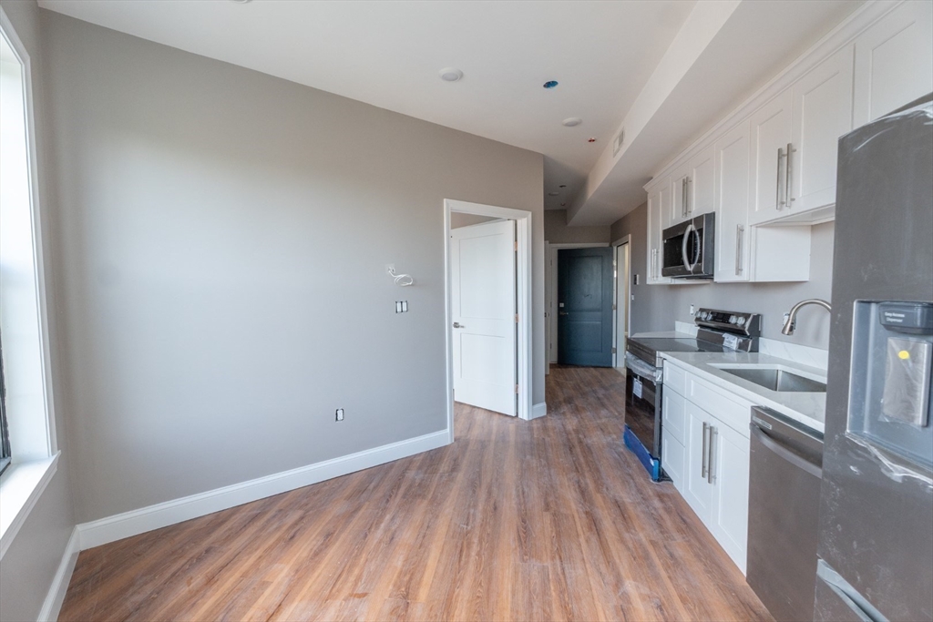 13 Nahant Street, Unit 2D Lynn, MA 01902 - Photo 2 of 11 a view of a kitchen with a sink stove cabinets and a window