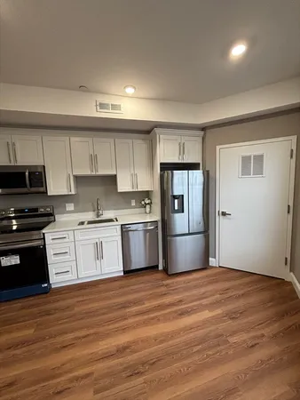 a large kitchen with a sink and stainless steel appliances