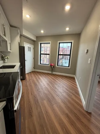 a view of a kitchen with wooden floor and electronic appliances