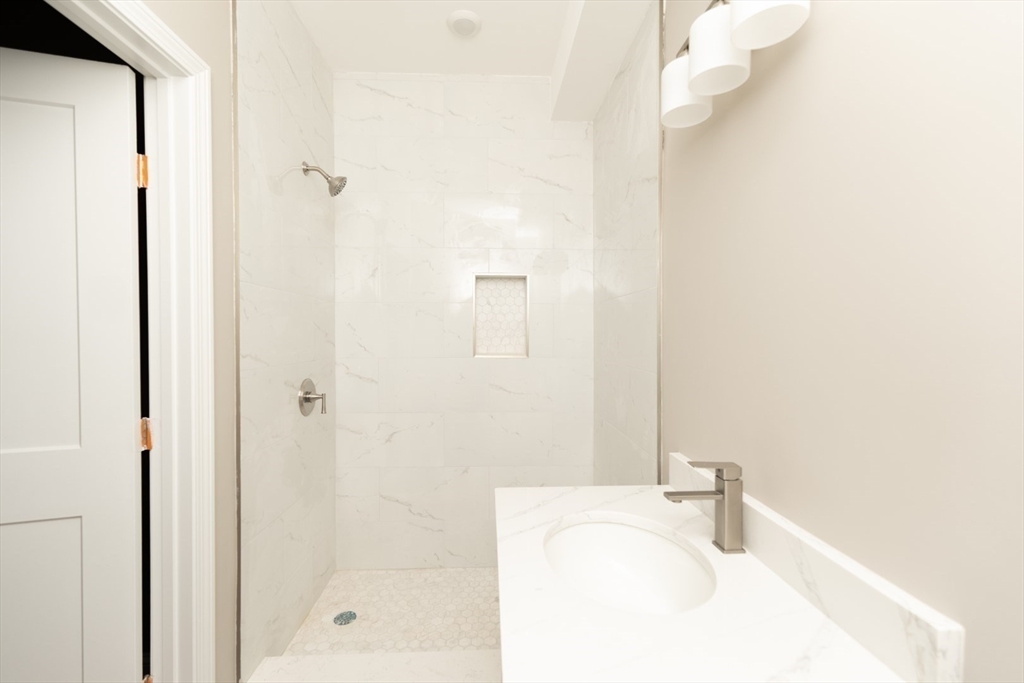 13 Nahant Street, Unit 2D Lynn, MA 01902 - Photo 8 of 11 a bathroom with a sink a mirror and shower