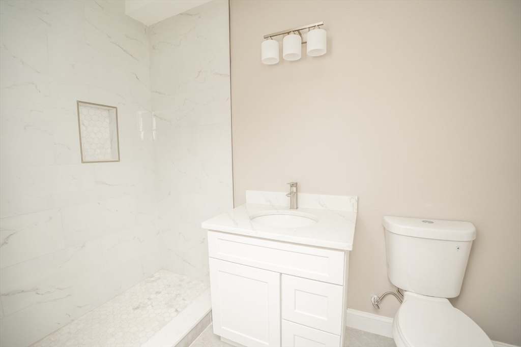 13 Nahant Street, Unit 2D Lynn, MA 01902 - Photo 9 of 11 a bathroom with a toilet a sink and a mirror