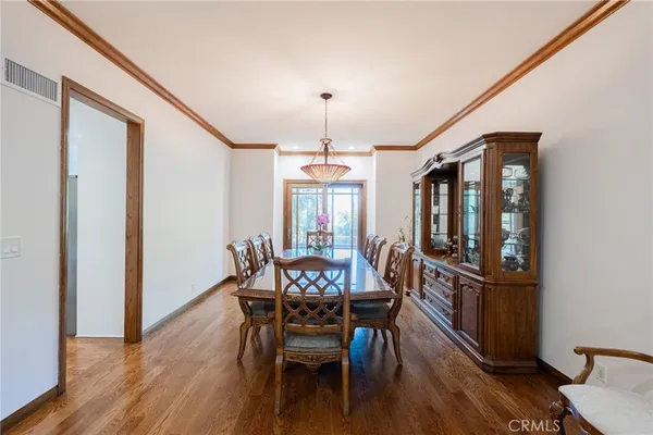 a kitchen with stainless steel appliances granite countertop a stove a sink dishwasher and a refrigerator with wooden floor