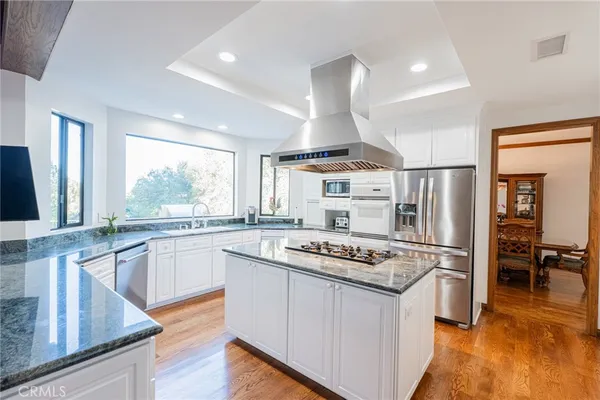 a kitchen with a stove a sink dishwasher a refrigerator and wooden cabinets