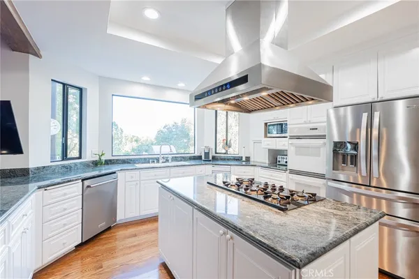 a kitchen with stainless steel appliances granite countertop a stove and a refrigerator