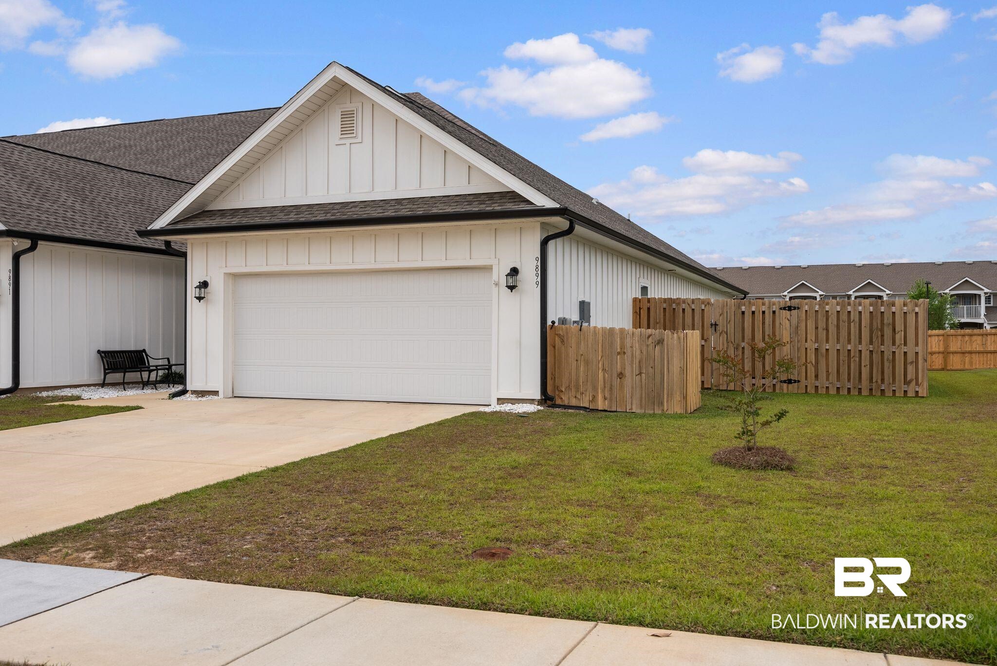 9899 Willet Way Foley, AL 36535 - Photo 34 of 37 Contemporary exterior with white board and batten siding, a dark shingle roof, and black gutters