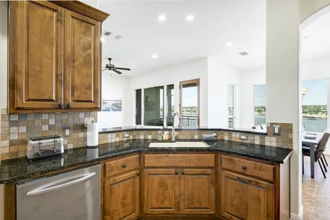 a kitchen with stainless steel appliances granite countertop a sink stove and cabinets