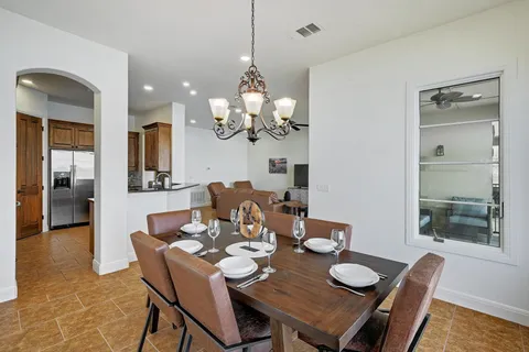 a dining room with furniture a chandelier and wooden floor