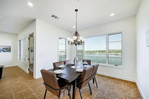 a dining room with furniture a chandelier and wooden floor