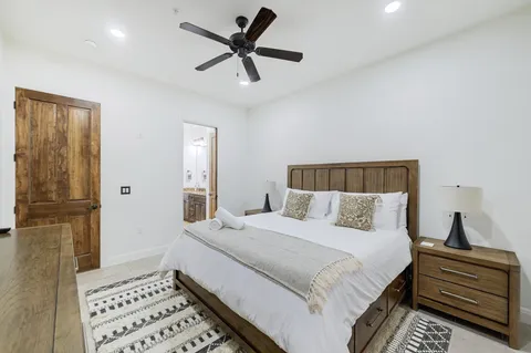 a bedroom with a large bed and a chandelier