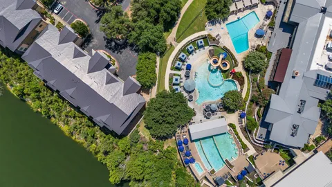 an aerial view of a swimming pool with outdoor seating and yard