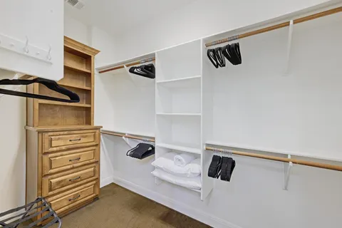 a view of walk in closet with empty racks