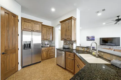 a kitchen with stainless steel appliances granite countertop a sink stove and refrigerator