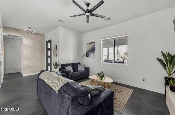 a living room with furniture a fireplace and kitchen view