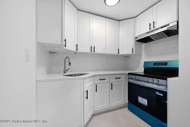 a front view of a house with a small yard and potted plants