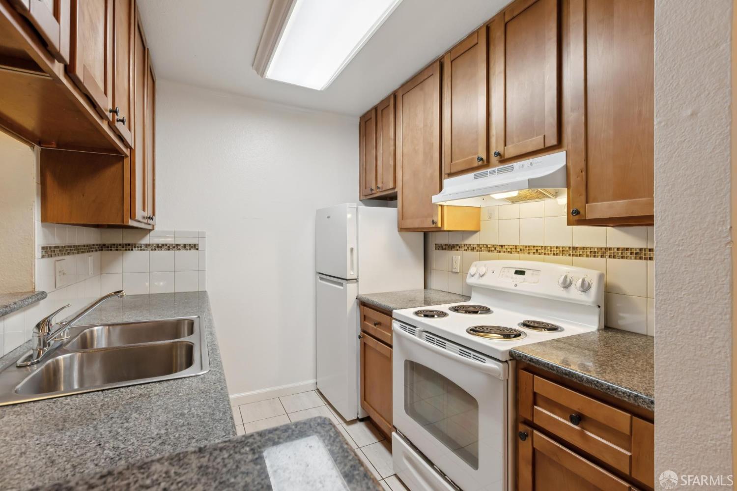 368 Imperial Way, Unit 233 Daly City, CA 94015 - Photo 8 of 39 a kitchen with granite countertop stainless steel appliances a stove a sink and a microwave