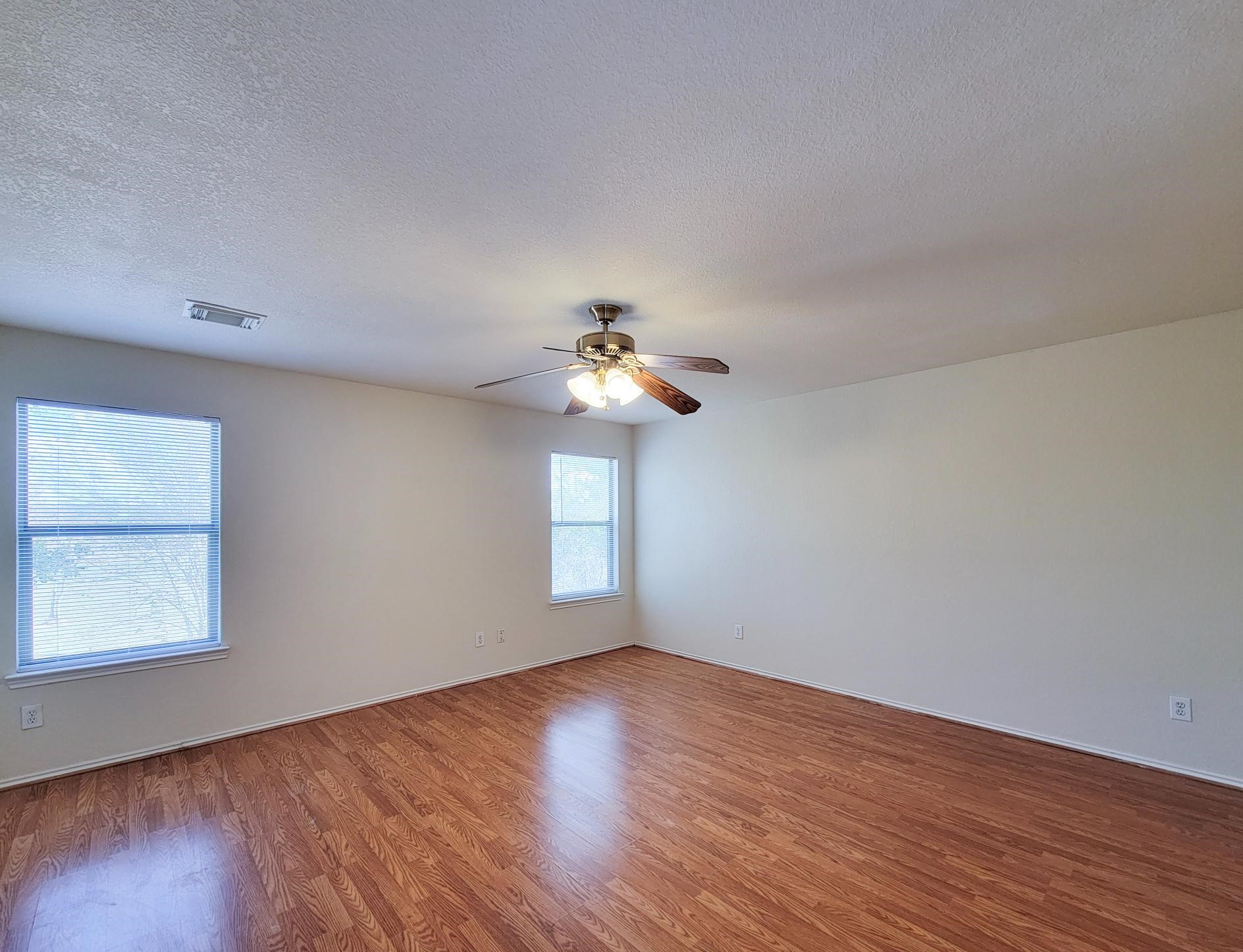 16306 Kendons Way Lane Cypress, TX 77429 - Photo 31 of 39 a view of a room with wooden floor ceiling fan and windows
