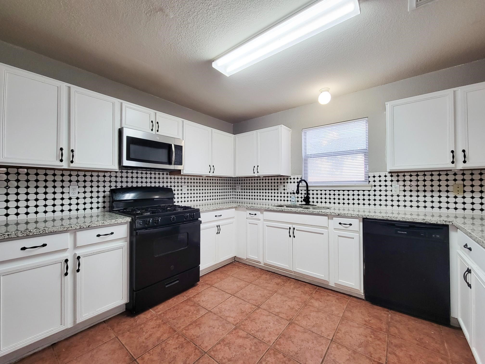 16306 Kendons Way Lane Cypress, TX 77429 - Photo 5 of 39 a kitchen with granite countertop a sink dishwasher stove and cabinets