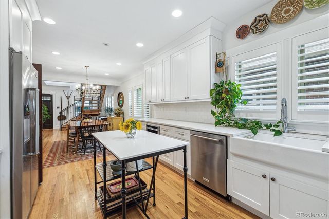 a kitchen with a table chairs refrigerator and microwave