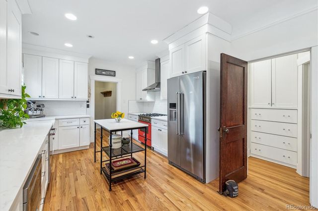 a kitchen with kitchen island white cabinets and stainless steel appliances