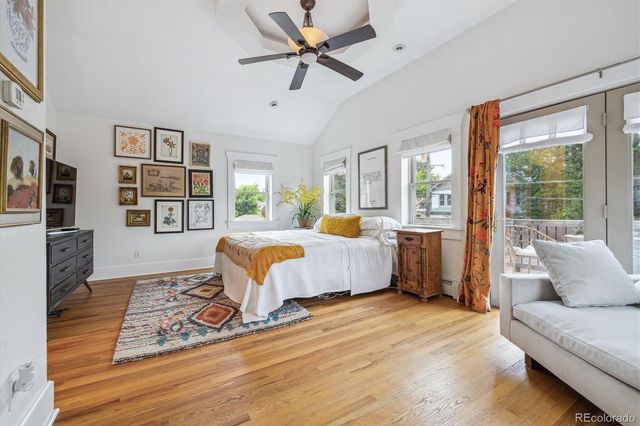a bedroom with a large bed a flat screen tv and a large window