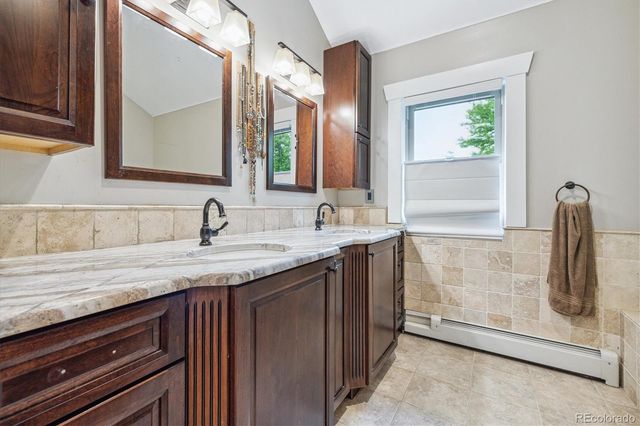 a bathroom with a granite countertop sink and mirror
