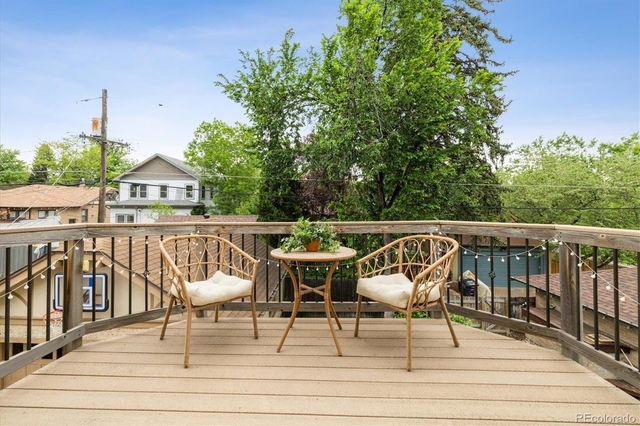 a view of roof deck with chairs and wooden fence